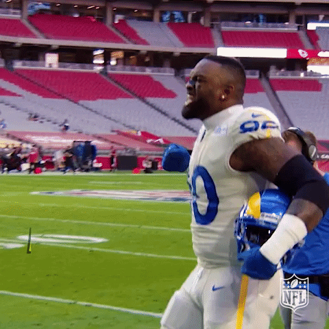 Sports gif. Los Angeles Rams defensive tackle Michael Brockers holds his helmet under his arm, pumps a fist and screams "Let's go!"
