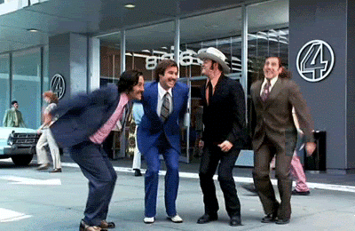 Movie gif. Paul Rudd, Will Ferrell, David Koechner, and Steve Carell as Brian Fantana, Ron Burgundy, Brick Tamland, and Champ Kind in the movie Anchorman jumping for joy in unison.