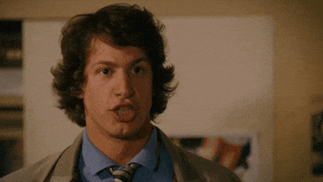 Movie gif. Wearing a beige jacket and tie, Andy Samberg as Rod Kimble from Hot Rod shouts at us in excitement: Text flies from his mouth: "Cool beans!"
