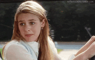 Movie gif. Alicia Silverstone as Cher in Clueless is driving. She looks away from the road and at the person in the passenger seat with a guilty expression. "My bad," she says, which appears as text, before breaking into a smile.