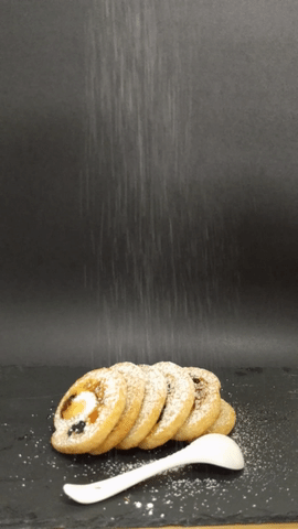 Moan dusting cream cheese scrolls with powdered sugar GIF