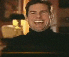 Celebrity gif. Tom Cruise laughs with a big open mouth, squinting, and claps his hands together.