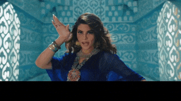 Music video gif. From the Badshah music video "Paani Paani." We zoom out on a woman in a blue dress, posing in ankle-high water in a large, light blue room resembling a palace. Yellow text at the bottom rushes in: "Mar jawaan."