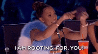 Reality TV gif. Mel B on America's Got Talent points energetically with both hands. She mouths the text that appears, "I Am Rooting. For. You!"