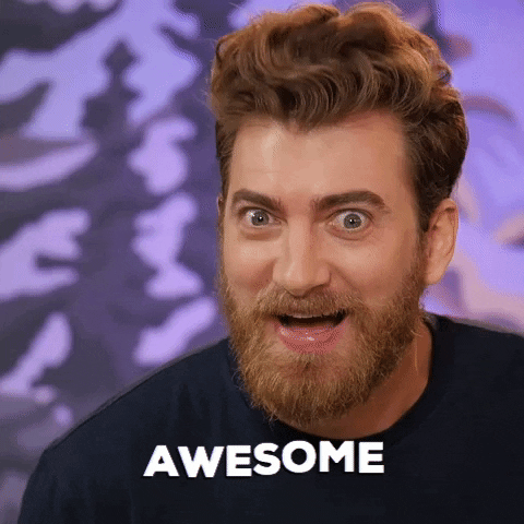 Video gif. Rhett McLaughlin on Good Mythical Morning, smiles at us as his head practically vibrates in a kind of neverending tiny nod. His hair wiggles and his eyes are wide. Text, "Awesome"