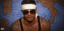 TV gif. DJ Pauly D from Jersey Shore sitting in front of a world map and wearing a large white headband pulls down his aviator sunglasses and says, "Yeahhhh buddy!"