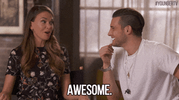 TV gif. Seated next to each other, Sutton Foster and Nico Tortorella of Younger share an amused conversation. Sutton speaks with a smile, and Nico nods agreeably as he repeats to us: Text, "Awesome."