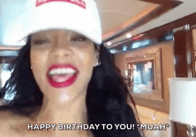 Celebrity gif. Rihanna is recording herself and she points at us and energetically says, "Happy birthday to you! Muah!" before pursing her lips  and giving us a smooch.