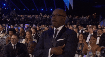 Celebrity gif. Courtney B Vance standing up at Screen Actors Guild awards show, listening while giving an affirmative fist bump.