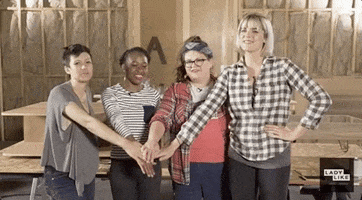 Celebrity gif. The Buzzfeed Ladylike team–Freddie Ransome, Jen Ruggirello, Devin Lytle, and Kristin Chirico–stand next to each other in an unfinished home. They al., look at us and hold their hands out in front of them in a pile and then throw them up excitedly.  