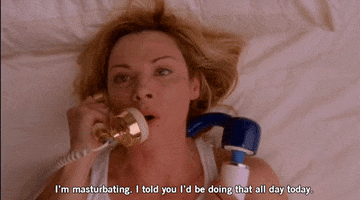 TV gif. Kim Cattrall as Samantha in Sex in the City lies in bed clutching a vibrator and speaking angrily into an antique style phone, saying, "I'm masturbating. I told you I'd be doing that all day."