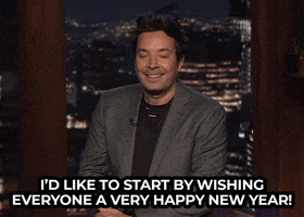 TV gif. Jimmy Fallon on The Tonight Show gets comfortable in his seat while saying "I'd like to start by wishing everyone a happy new year!" which appears as text.