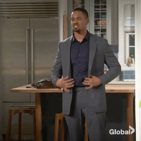 TV gif. Damon Wayans Jr. as Jake in Happy Together rips off his jacket, covers his mouth with a finger, and slides down a wall seductively.