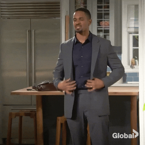 TV gif. Damon Wayans Jr. as Jake in Happy Together rips off his jacket, covers his mouth with a finger, and slides down a wall seductively.