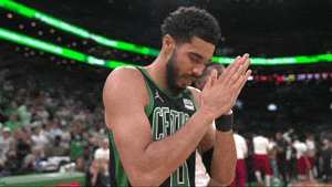 Sports gif. Jayson Tatum of the Boston Celtics bows his head and rubs his hands together in prayer during a game. He kisses his hand, points at the crowd, then tugs his ear like he's telling you to listen.