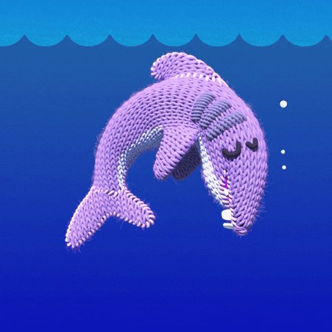 Cartoon gif. A knitted shark is bent over as it sleeps under water. A glove on a stick reaches up to poke the shark in the nose, and it wakes up, jumping excitedly out of the water, pausing in the air as text appears, "Good morning!" The shark falls back into water and it repeats in a perfect loop. 