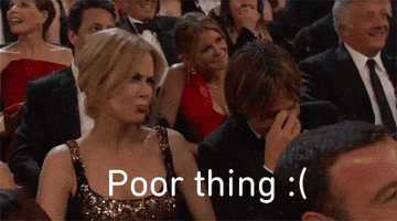 Celebrity gif. Nicole Kidman and Keith Urban sit next to each other in the audience of a reward show. Nicole Kidman looks up at the stage and pouts, saying, “Poor Thing.” Keith Urban looks down, pinching the bridge of his nose, and shaking his head.