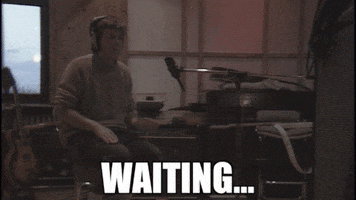 Celebrity gif. Paul McCartney wears headphones as he taps a rhythm on his legs in a music studio. Text, "Waiting."