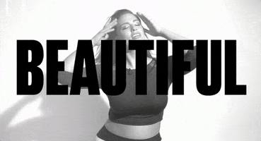 Celebrity gif. Ashley Graham pushes back her long hair and breaks into a wide smile, shoulders hunching forward with laughter. Bold block letters across the screen read, "Beautiful."