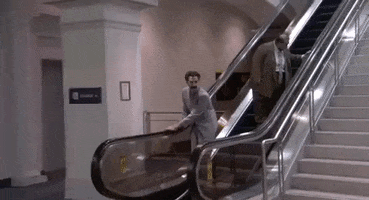 sacha baron cohen escalator GIF