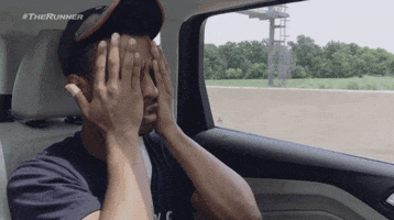 Reality TV gif. Riding in the back of a car, an overwhelmed and frustrated contestant on The Runner runs his hands down his face as if to say, “Ughhh.”