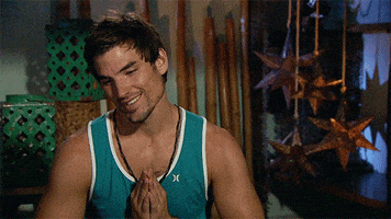 Reality TV gif. A man from The Bachelor in Paradise puts his hands in prayer hands and looks towards the sky, hoping.