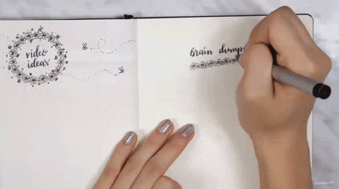 How to rid yourself of negative thoughts: Person writing in journal with title 'brain dump'