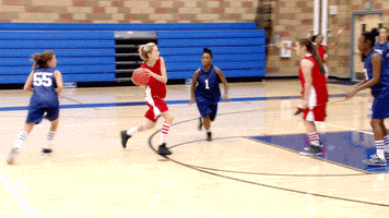 Sports gif. In a women’s basketball game, a player gets blocked while driving to the basket and fumbles the ball, throwing it away from her teammates.