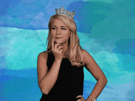 Celebrity gif. Wearing her Miss America 2017 crown, Savvy Shields stands with one hand on her hip and the other tapping her chin and looking around as if she is pondering something.