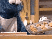 Cookie monster putting cookies in the oven
