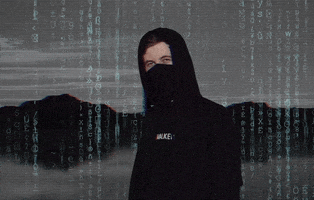 Music video gif. Alan Walker points straight at us. Behind him is a dark gray background of mountains above clouds, and a "Matrix"-style scrolling text effect is layered over it.