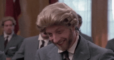 Movie gif. Chris Elliot as Nathaniel in Cabin Boy wears a suit and a powdered wig as he covers his mouth and cracks up laughing.