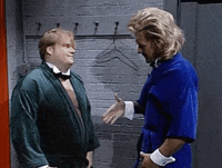 Chris Farley ripping off his shirt with exaggerated fervor in the Chippendales routine