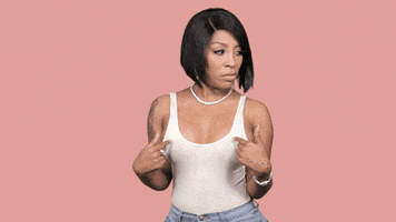 Celebrity gif. K Michelle looks around, side to side, then looks center at us and points to herself and asks, "Who, me?" which appears as text.