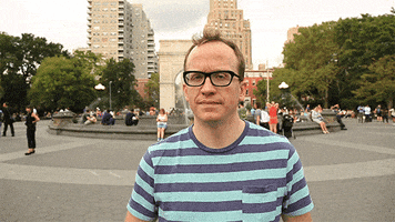 Celebrity gif. Chris Gethard is standing at Washington Square Park and he looks at us with a smile with shooting us a double thumbs up.