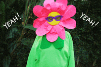 Video gif. Person in sunglasses dressed head-to-toe in a colorful flower costume. They toss their arms as the word "Yeah!" appears. The humanoid flower then multiplies into three flowers, flexing a bicep in unison. Text flashes, "You Did It"