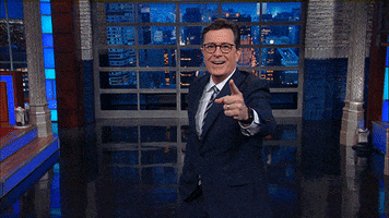Late Show gif. Stephen Colbert points at us expectantly, looking excited and he juts his finger out even more as he says, "Ah ha!" as if he's caught us in the act.