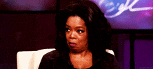 TV gif. Oprah Winfrey frowns and gives a side-eye, as if to say, “oops.”