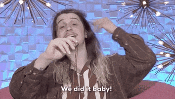 Reality TV gif. A contestant from Big Brother says into the microphone, "We did it baby!" while raising his arm in celebration.