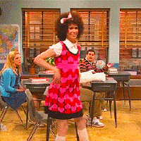 SNL gif. Kristen Wiig as Gilly puts her hands on her hips as she smiles at us and sashays to the front of a classroom.