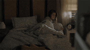 TV gif. Allison Williams as Marnie in Girls sits up in bed as daylight streams in the window. She grabs a corner of her comforter then lies back and pulls it over her face.