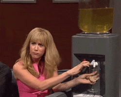 SNL gif. Kirsten Wiig is pouring herself a glass of wine from a huge water dispenser that has wine in it. She mocks someone by opening and closing her mouth noisily.