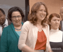 The Office gif. Ellie Kemper as Erin cheers, dances, and shouts "Yes!" with her coworkers, who are all celebrating and congratulating each other.