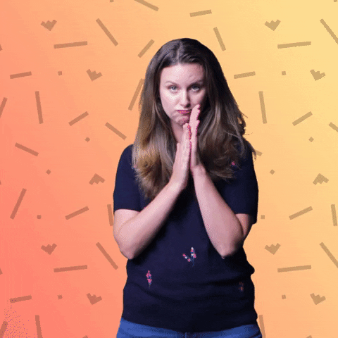 Video gif. Erica Seamster looks at us with a serious expression on her face, rubbing her hands together like she has an evil plan. Text appears behind her against a yellow-orange background, "Mwahahahahaha."