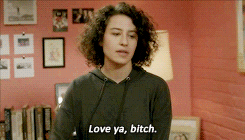 TV gif. Ilana Glazer as Ilana in Broad City stands up straight, salutes with two fingers, and says, “Love ya, bitch.”