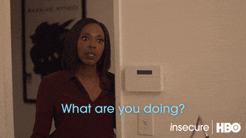 TV gif. Yvonne Orji as Molly on Insecure, leaning into a doorway and saying sternly, "What are you doing?" as Issa Rae, sitting at a computer, looks back as if she has been caught.
