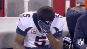Sports gif. Teddy Bridgewater from the Denver Broncos is sitting on the bench with his head in his hands. He rubs his head slowly in frustration.