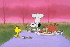 Peanuts gif. Wearing a chef’s hat, Snoopy offers Woodstock one end of the wishbone at the Thanksgiving table. Woodstock smiles and grasps the bone as they struggle to beak it. The bone snaps as Snoopy and Woodstock fly backward, Woodstock with the larger piece.