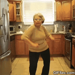 Video gif. An older lady eagerly dances, attempting to copy something she&#39;s seen but ends up looking like a chicken dance. Two more friends pop up and the 3 of them do the dance together, rolling their hips and waving their hands in the air, having a grand time.