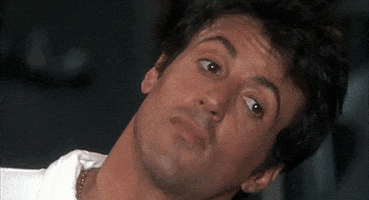 Movie gif. A younger Sylvester Stallone gives us his take on the classic facepalm.